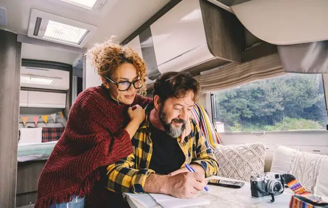 adult couple planning a trip with a map in a rv