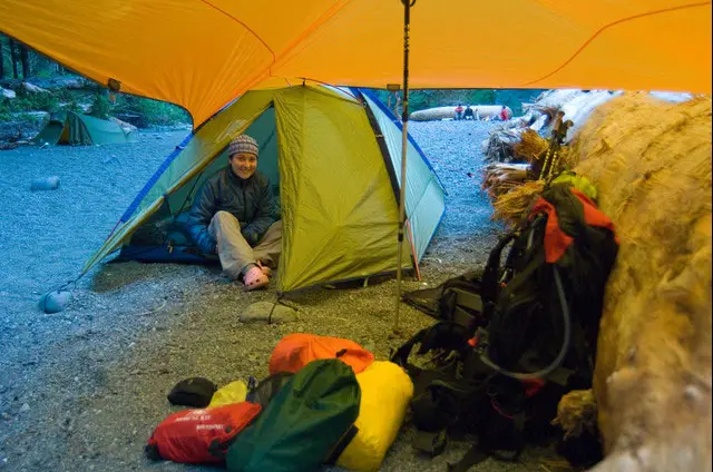 camping with tents and a tarp in the middle as roof