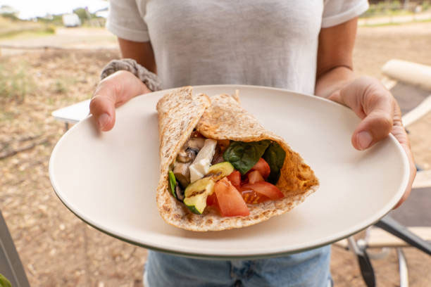 Tacos and Wraps on a plate hold by a woman